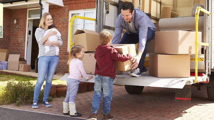  Family Unpacking Moving In Boxes From Removal Truck