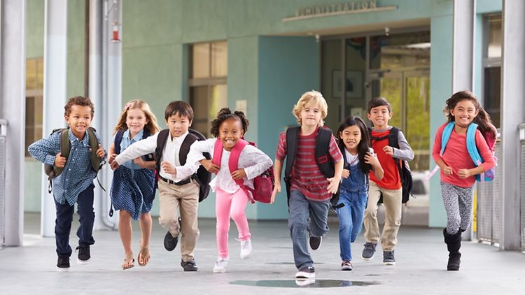  Group of elementary school kids running in a school corridor